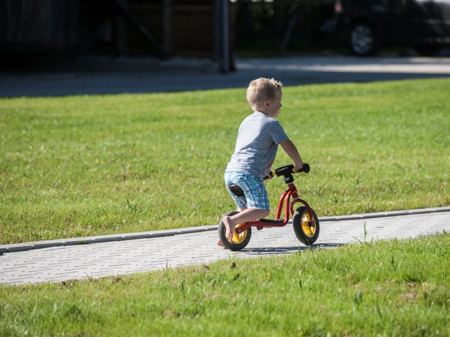 Kinderen gebruiken het erf als fietsparcour