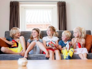 Kinderen genieten van hun chips op de bank